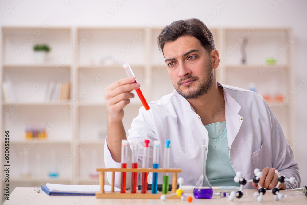 Young male chemist sitting at the lab Young male chemist sitting at the lab