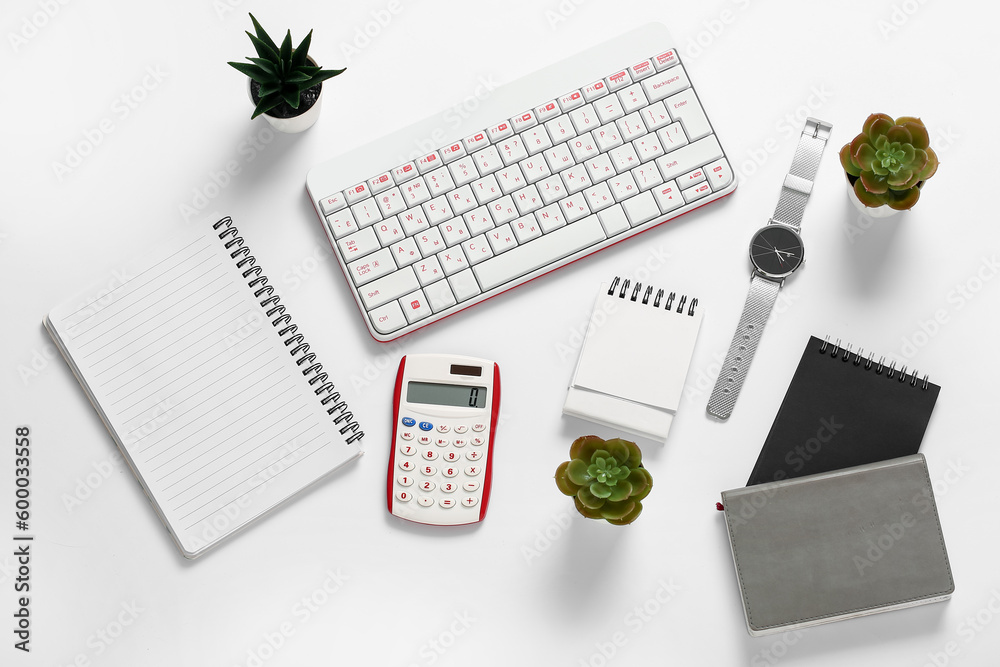 Composition with keyboard, calculator, notebooks and wristwatch on white background