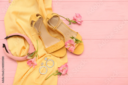 Composition with stylish female accessories, shoes and alstroemeria flowers on color wooden background