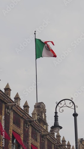 Bandera México izada en edificio en una tarde de Zócalo de la Ciudad de México photo