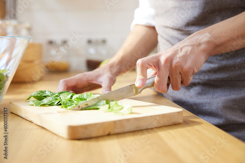 close up of a chef hands cutting vegetable salad on a cutting board in the kitchen