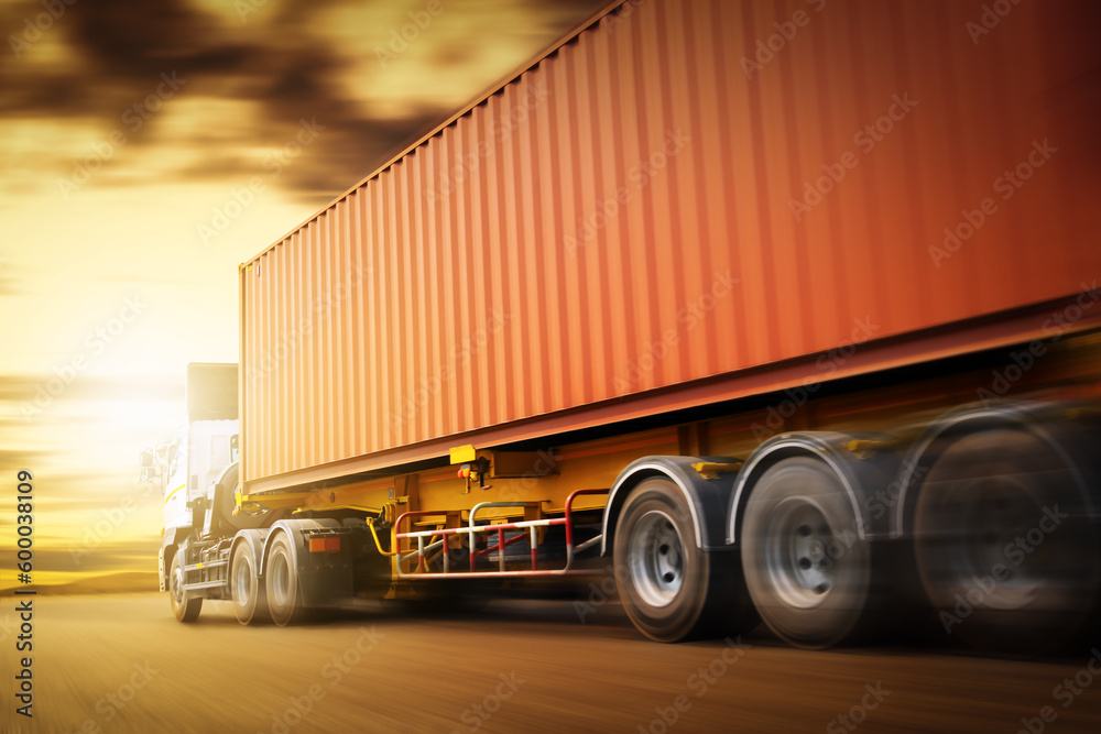 Speed Motion of Semi Trailer Truck Driving on The Road with The Sunset. Commercial Truck, Express Delivery Transit. Shipping Container Truck Transport. Freight Trucks Logistics Cargo Transport.