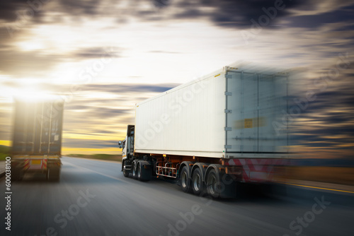 Speed Motion of Semi Trailer Truck Driving on The Road with The Sunset Sky. Commercial Truck, Express Delivery Transit. Shipping Container Truck Transport. Freight Trucks Logistics Cargo Transport.