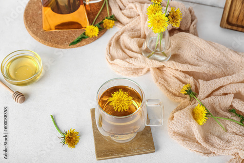 Glass cup of healthy dandelion tea on white table