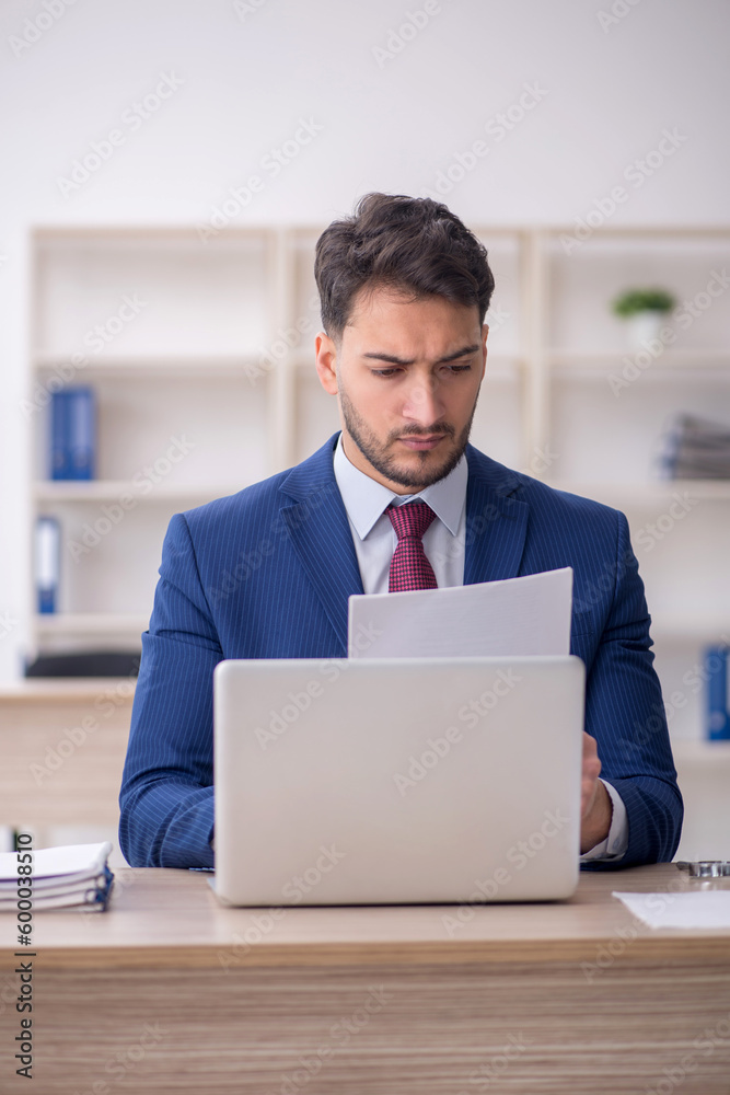 Young male employee working in the office Young male employee working in the office