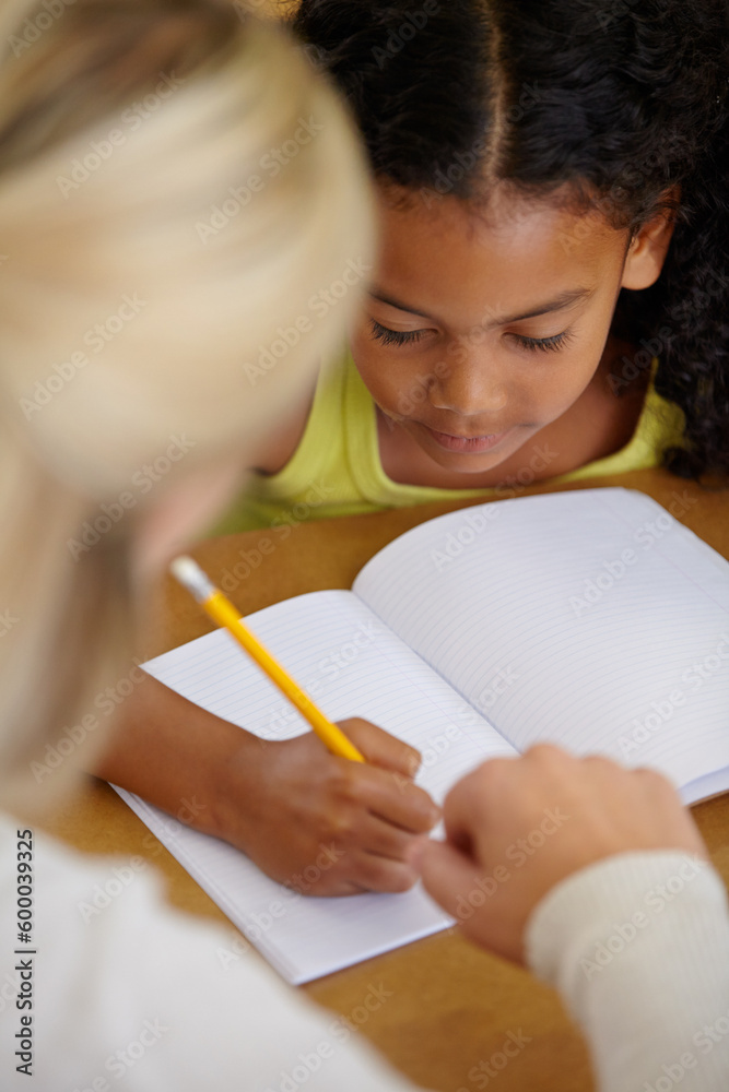 Teacher help student, education and writing in notebook with pencil, teaching and learning for growth and development. People in classroom to learn, academic study with young girl and woman at school Teacher help student, education and writing in notebook with pencil, teaching and learning for growth and development. People in classroom to learn, academic study with young girl and woman at school