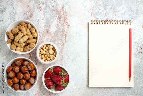 top view hazelnuts and peanuts with strawberries on white background nut snack walnut berry fruit