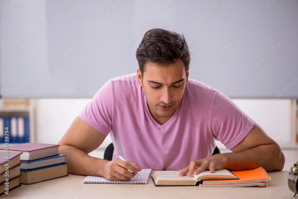 Young male student preparing for exams in the classroom Young male student preparing for exams in the classroom