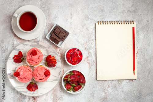 top view pink strawberry cakes with cream and cup of tea on a white background fruit tea cake biscuit sweet cookie