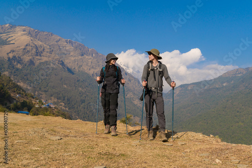 A young couple travellers trekking in Poon Hill view point in Ghorepani, Nepal.