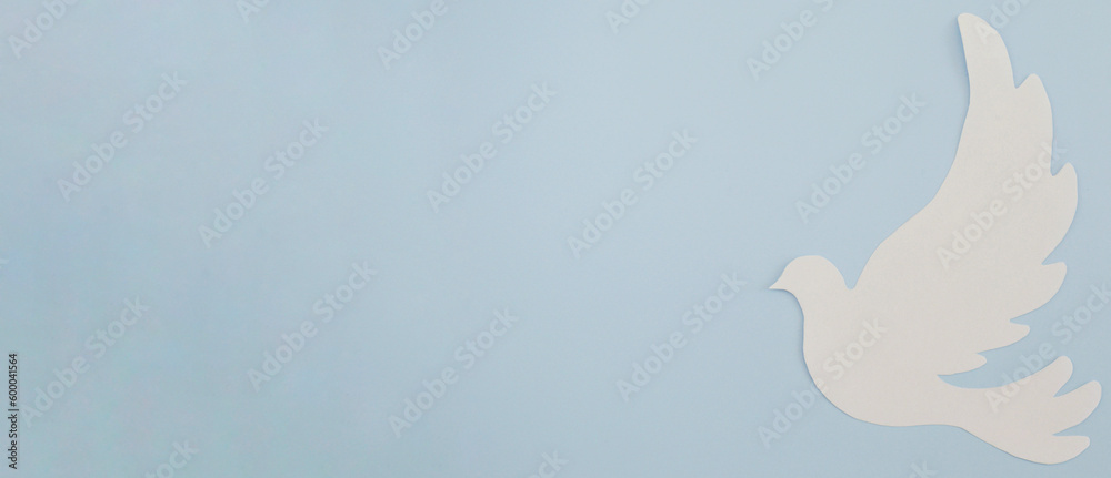 White paper origami bird on blue background. World Day of Peace. Day Against Humiliation. International Day Of Human Fraternity. International Day of Living Together in Peace. Banner White paper origami bird on blue background. World Day of Peace. Day Against Humiliation. International Day Of Human Fraternity. International Day of Living Together in Peace. Banner