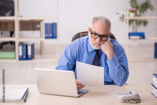 Old male employee working in the office