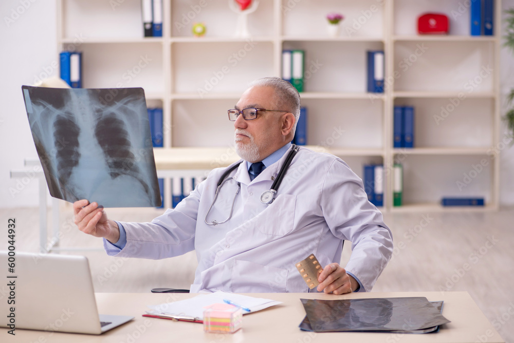 Old male doctor radiologist working in the clinic