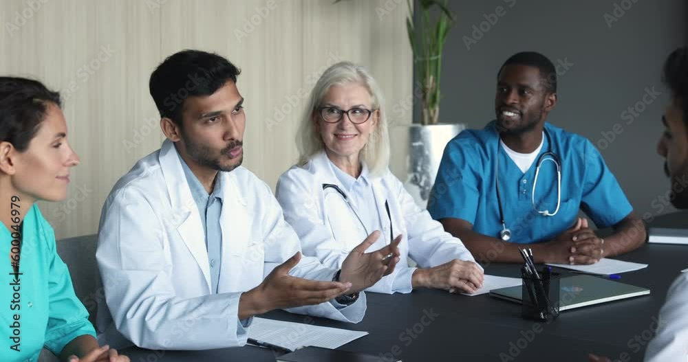 Two young men physicians in white coats accomplish group meeting, medical council of professionals with hands shake, express respect for cooperation, gratitude for successful collaboration or teamwork Two young men physicians in white coats accomplish group meeting, medical council of professionals with hands shake, express respect for cooperation, gratitude for successful collaboration or teamwork