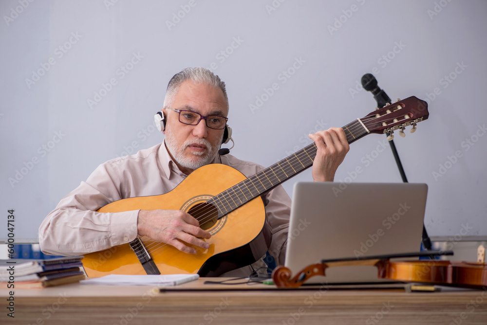 Obraz premium Old male music teacher in the classroom