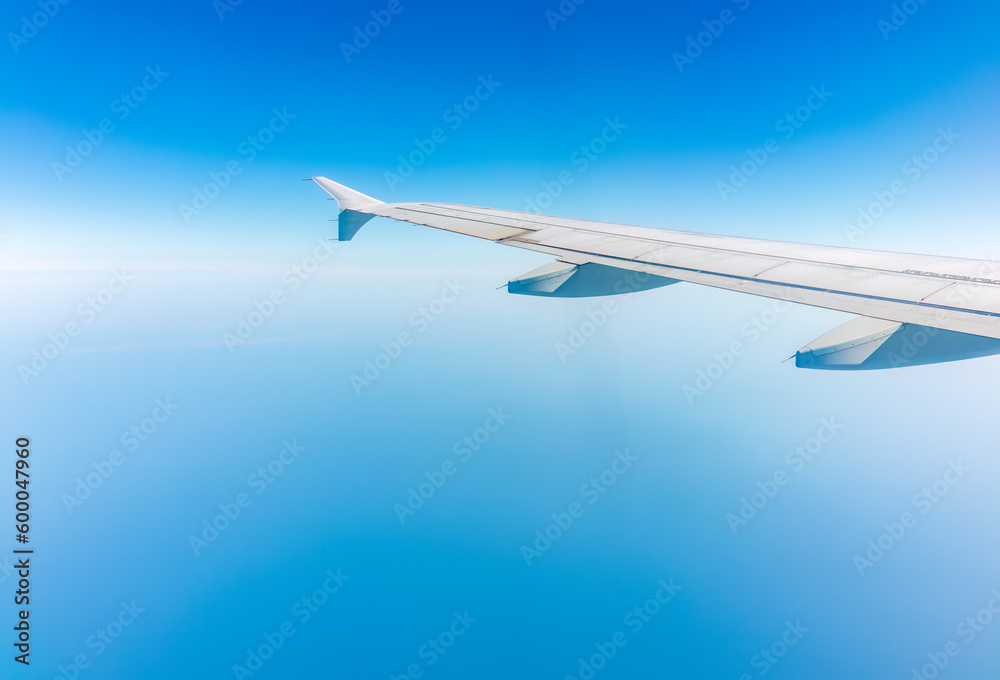 Fototapeta premium View from the airplane window at a beautiful cloudy sky and the airplane wing