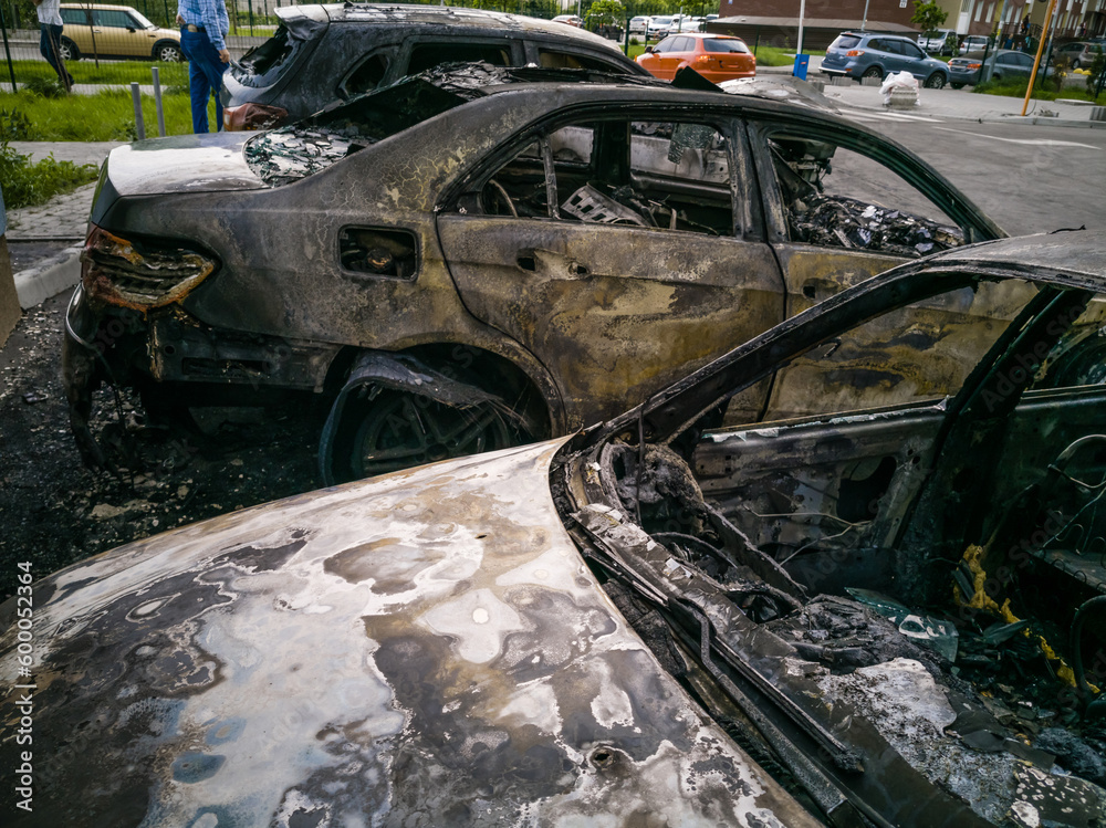 Broken and burned cars in the parking lot, accident or deliberate vandalism. Burnt car. Consequences of a car accident. Damaged by arson. Dump of civilian vehicles shot by Russian troops in Ukraine.
