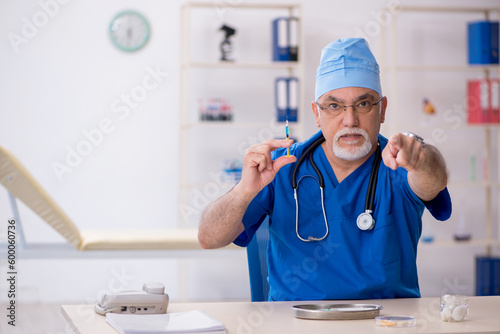 Old male doctor working in the clinic © Elnur