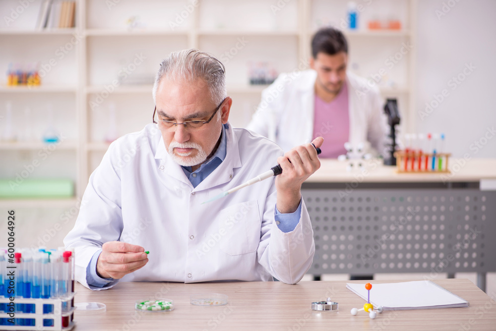 Two male chemists working at the lab Two male chemists working at the lab