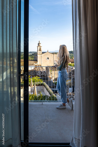 Caucasian woman with long blonde hair looking village at the hotel balcony photo