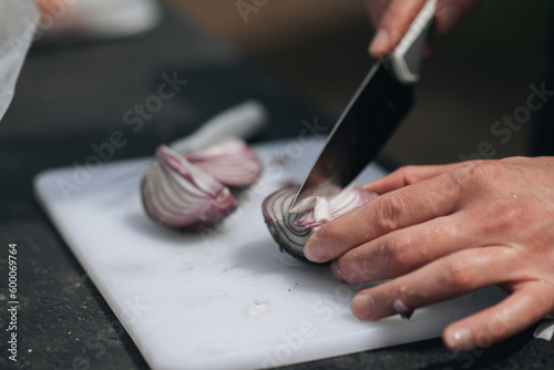 Cutting an onion in an outdoor kitchen