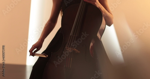 Single woman playing the cello, close-up and medium close-up, cello bow and strings, smooth transitions of the camera from focus to out-of-focus, beautiful filmic, artistic shots.