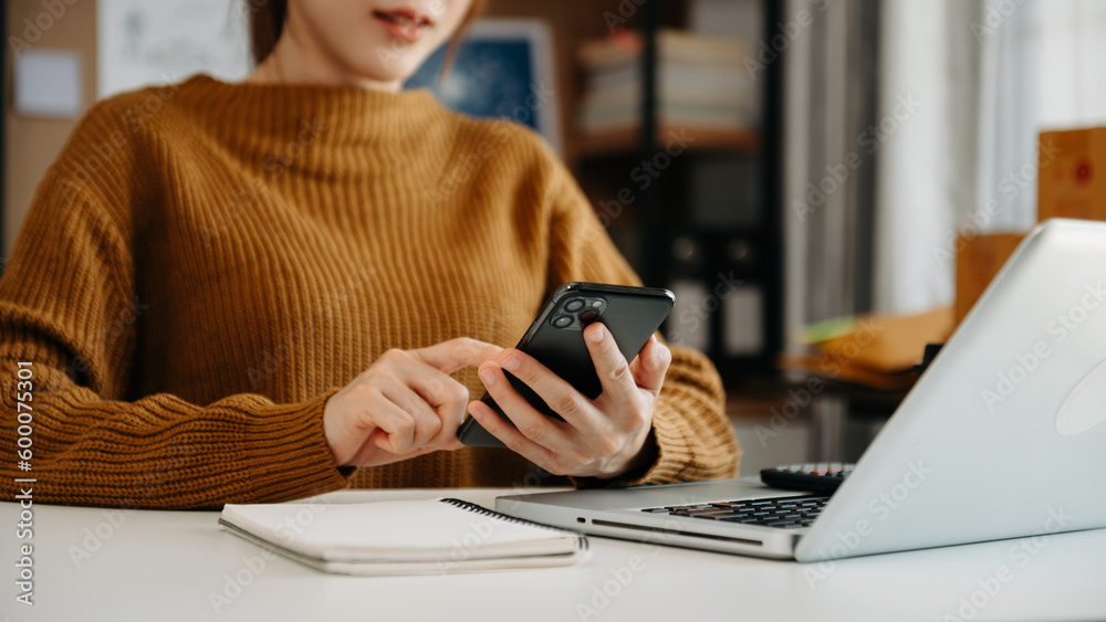 Woman hand using a laptop, smartphone and tablet and writing notebook at the office of her business online shopping. Woman hand using a laptop, smartphone and tablet and writing notebook at the office of her business online shopping.