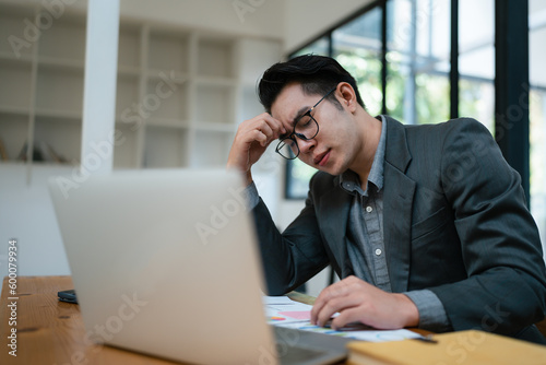 Portrait of business owner, man using computer and financial statements Anxious expression on expanding the market to increase the ability to invest in business.