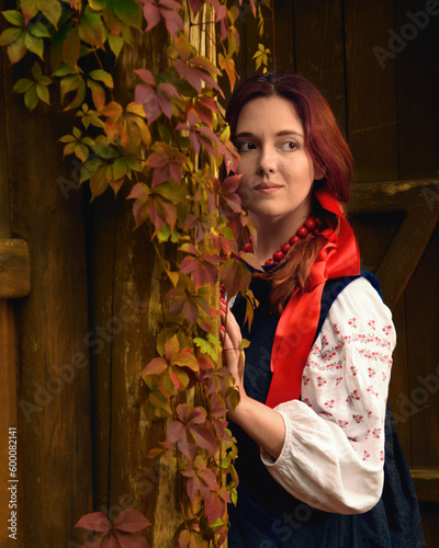 Obraz na płótnie Smiling young redhead woman dressed traditional ukrainian embroidered clothes and red beads looking away. Vintage outfit. Half-length portrait. w salonie