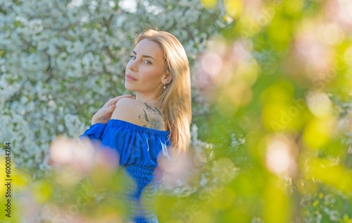 Femininity concept, tender modern European lady in blue dress at evening garden