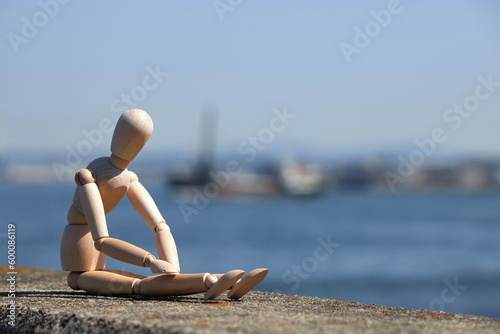 Foto 大阪湾の沿岸の公園の堤防で座っているマネキン人形