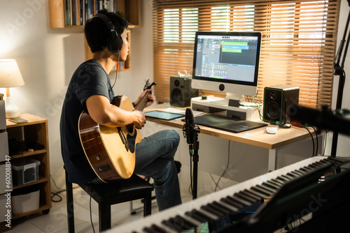 Asian man making music at home studio