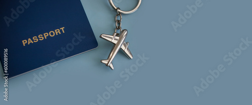 Passport, airplane keychain on a colored background
