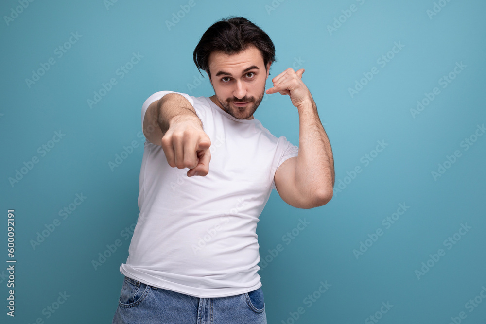 young brunette guy in a white t-shirt points his finger at the camera young brunette guy in a white t-shirt points his finger at the camera