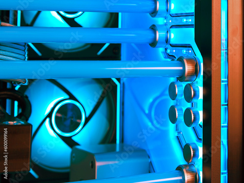 View from inside a fragment of a water cooling system in a high-performance modern computer with a beautiful blue LED backlight. Soft focus.