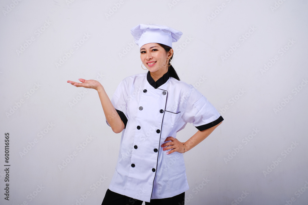 Photo of smiling female Asian chef standing with open palms, warm welcome gesture on empty space or copy space for product isolated on white background Photo of smiling female Asian chef standing with open palms, warm welcome gesture on empty space or copy space for product isolated on white background