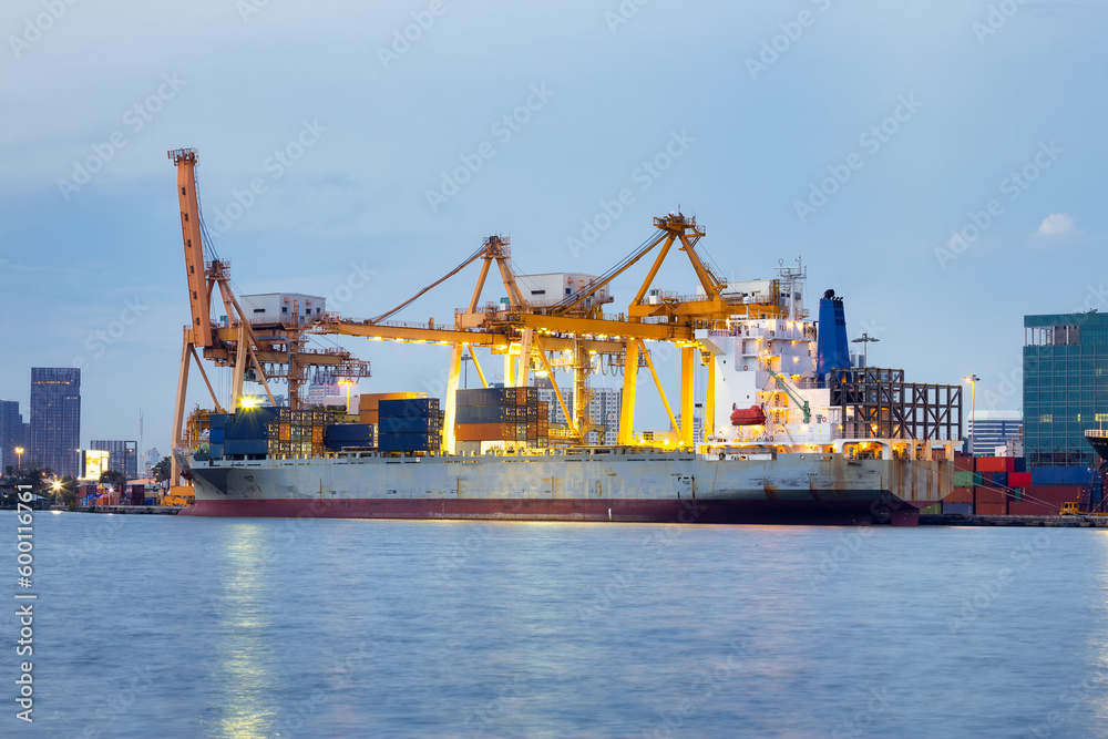 Cargo ship at dock, port or harbor. To loading cargo container, work with crane. Concept of business and industry i.e. shipping, logistics, international trade, freight transport and import export.
