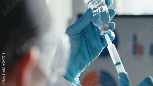 A doctor in a medical laboratory types a doctor into a syringe for injection in a close-up. Laboratory tests on the video show the process of testing for a new drug. Chemical research photo