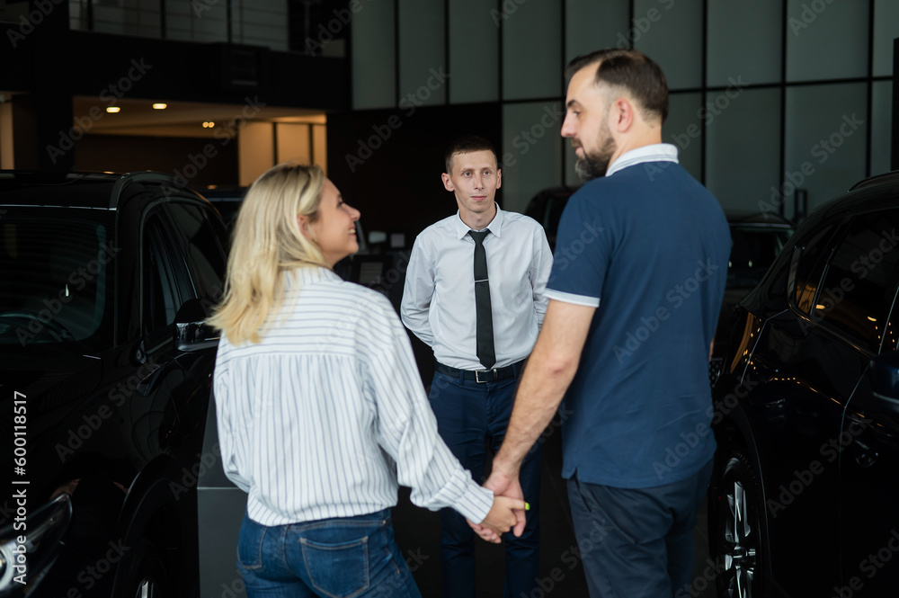 Happy caucasian couple choosing a new car in a car dealership. Happy caucasian couple choosing a new car in a car dealership.