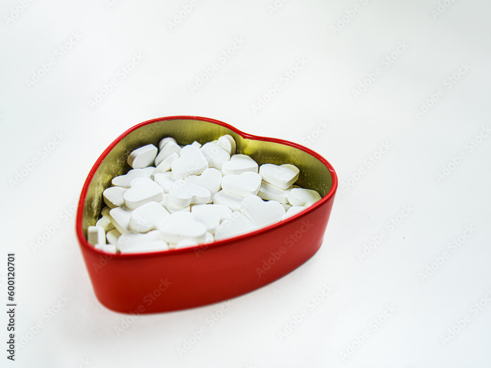 heart shaped pills in a heart shaped box on a white background heart shaped pills in a heart shaped box on a white background