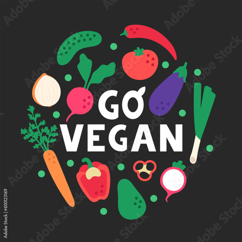 Phrase go vegan with vegetables in a circular composition. Flat bright vegetables on a black background. Healthy vegetarian lifestyle.
