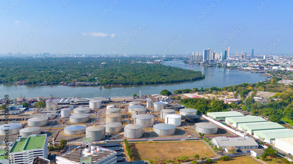 Naklejka premium Aerial view of petrochemical oil refinery and sea in industrial engineering concept in Bangna district at night, Bangkok City, Thailand. Oil and gas tanks pipelines in industry. Modern metal factory.