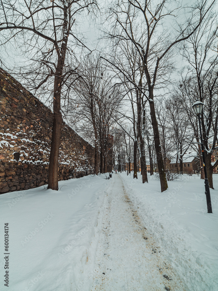 snow-covered path next to the old city walls snow-covered path next to the old city walls