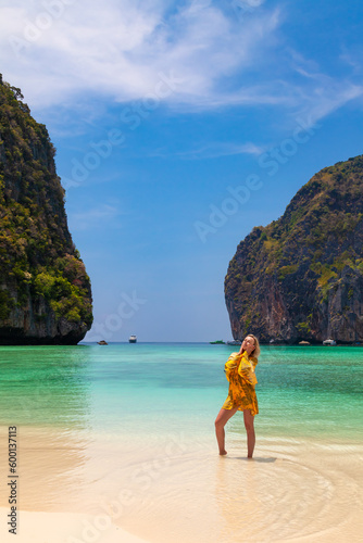 Beautiful young blonde woman in orange dress on a Maya Bay Beach during excursion of phi phi leh island in andaman sea thailand. © Aleksandr Kondratov