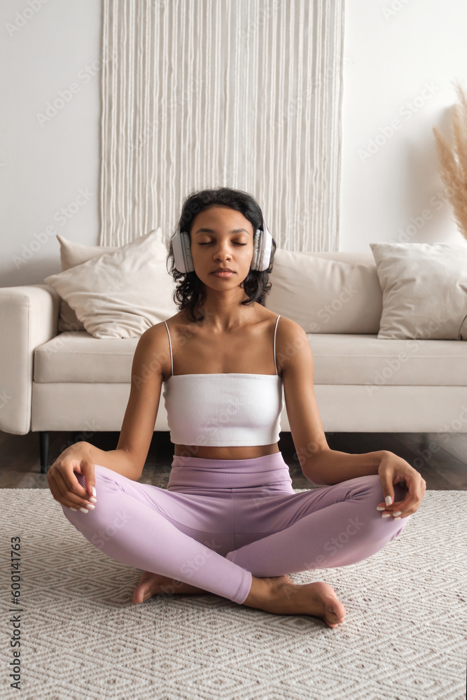 Vertical banner with serene black woman in headphones meditating,listening to relaxing music Vertical banner with serene black woman in headphones meditating,listening to relaxing music