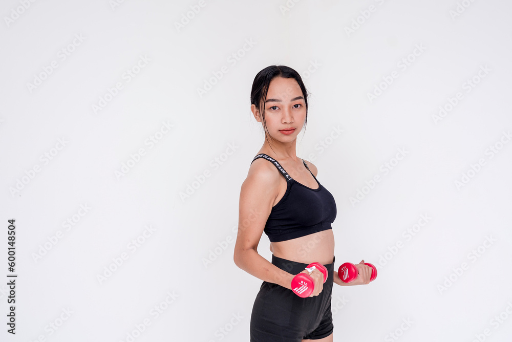 A sporty and young woman weightlifting and working out using a dumbbell, side view. Isolated on a white background. A sporty and young woman weightlifting and working out using a dumbbell, side view. Isolated on a white background.