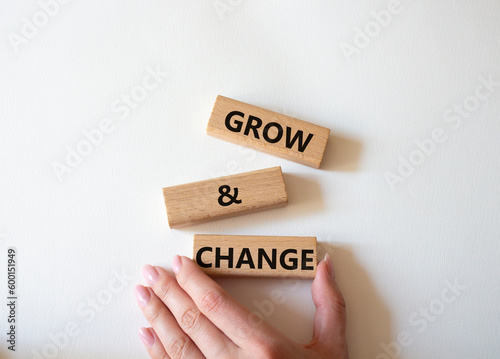 Grow and Change symbol. Concept word Grow and Change on wooden blocks. Businessman hand. Beautiful white background. Business and Grow and Change concept. Copy space