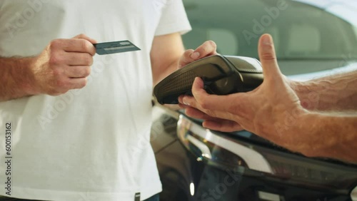 Cropped man customer buyer client male hand hold wireless bank payment terminal process acquire credit card payments buy automobile in car showroom vehicle salon dealership store motor show indoor.