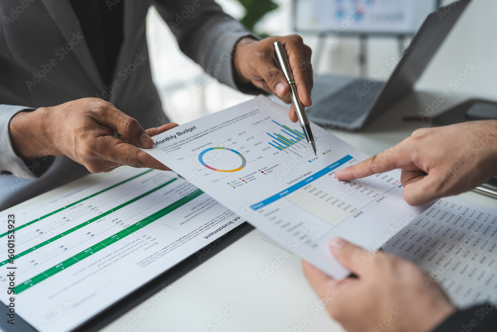 Businessman consultant, teamwork is talking Plan to analyze the cost graph. Investment and market data on charts and documents on office desk. Businessman consultant, teamwork is talking Plan to analyze the cost graph. Investment and market data on charts and documents on office desk.