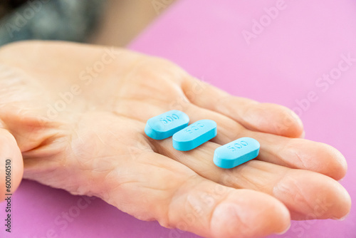 Blue pills on the hand.